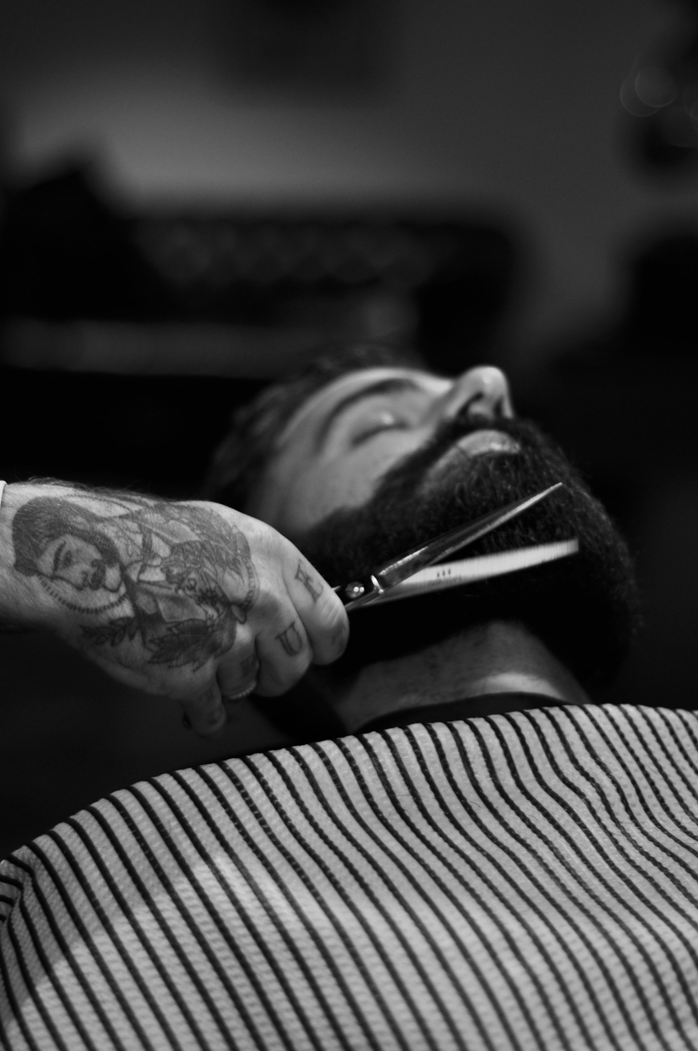 Black and white close-up of a straight-razor beard trim