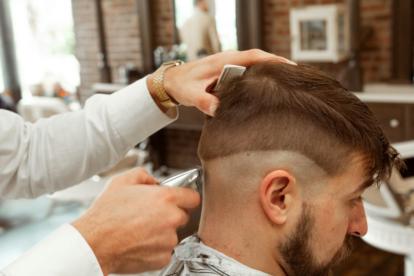 Barber working a tight fade with clippers
